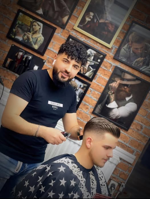 Barberare arbetar med maskin och sax